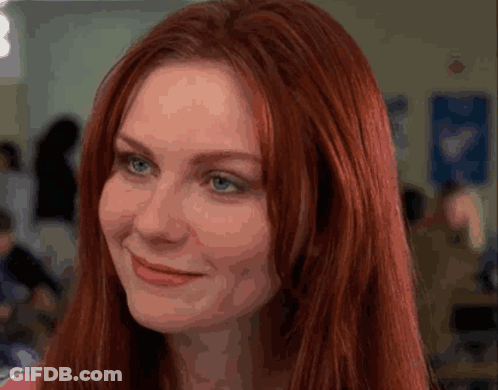 A Close Up Of A Woman With Red Hair And Blue Eyes GIF