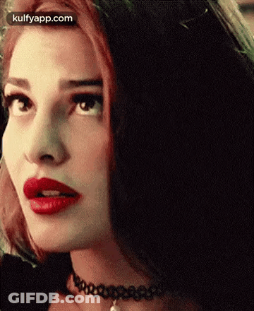 A Close Up Of A Woman With Red Lipstick And A Choker On Her Neck . GIF