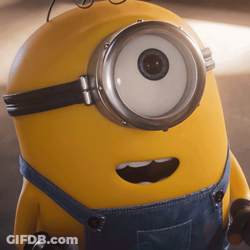 A Close Up Of A Yellow Minion Wearing Overalls GIF