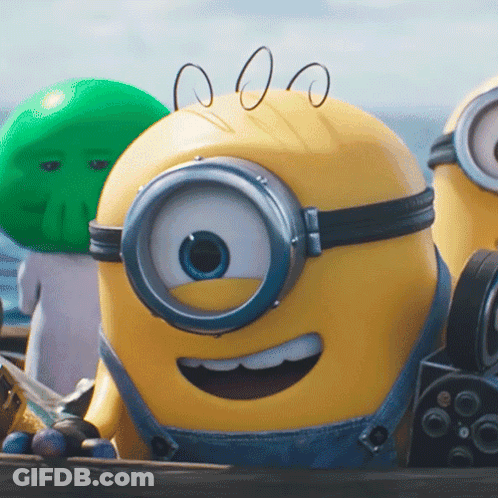 A Close Up Of A Yellow Minion Wearing Overalls GIF
