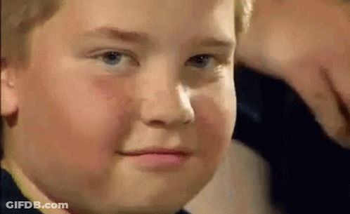A Close Up Of A Young Boy 'S Face With A Serious Look On His Face . GIF