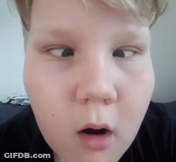 A Close Up Of A Young Boy 'S Face With His Mouth Open Making A Funny Face . GIF