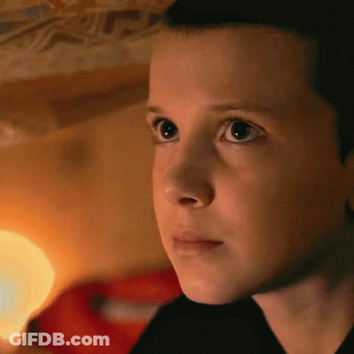 A Close Up Of A Young Girl 'S Face With A Light Behind Her GIF