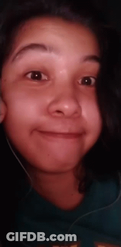 A Close Up Of A Young Girl 'S Face With Headphones On . GIF