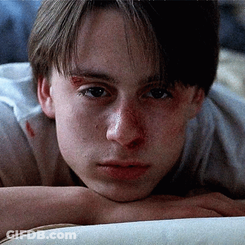 A Close Up Of A Young Man Laying On A Bed GIF