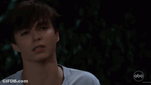 A Close Up Of A Young Man 'S Face In A Dark Room . GIF