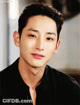 A Close Up Of A Young Man 'S Face Wearing A Black Shirt And Looking At The Camera . GIF