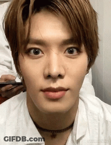 A Close Up Of A Young Man 'S Face Wearing A Choker Necklace And A White Shirt . GIF