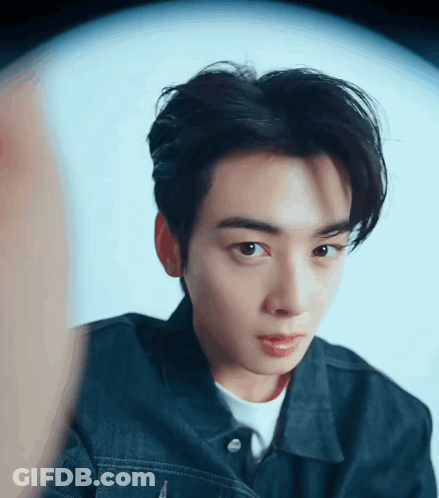 A Close Up Of A Young Man 'S Face Wearing A Denim Jacket GIF