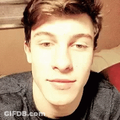 A Close Up Of A Young Man 'S Face Wearing A Grey Shirt . GIF