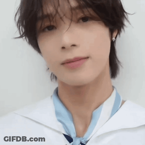 A Close Up Of A Young Man 'S Face Wearing A White Shirt And A Blue Scarf . GIF