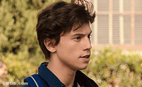 A Close Up Of A Young Man 'S Face With A Backpack On His Back . GIF