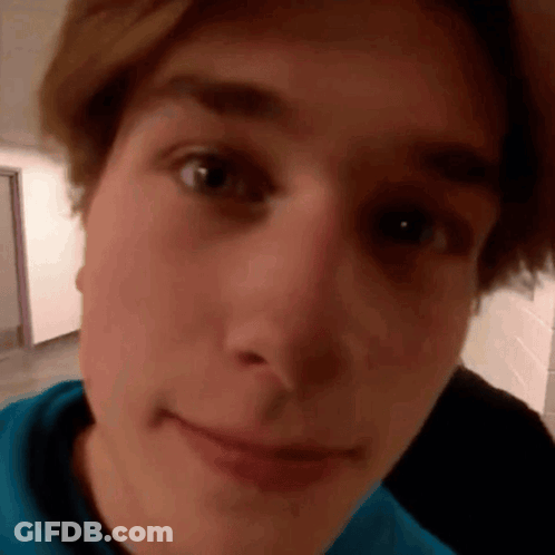 A Close Up Of A Young Man 'S Face With A Blue Shirt . GIF