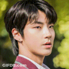 A Close Up Of A Young Man 'S Face With A Blurred Background And A Red Jacket . GIF