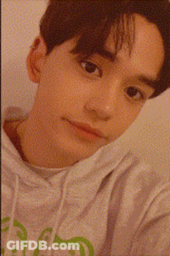 A Close Up Of A Young Man 'S Face With A Candle In The Background GIF