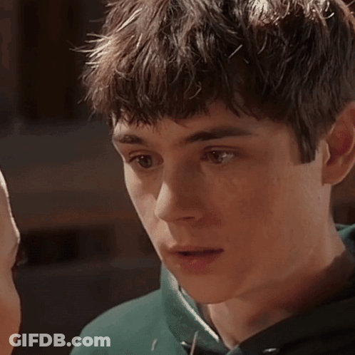 A Close Up Of A Young Man 'S Face With A Green Sweatshirt On GIF