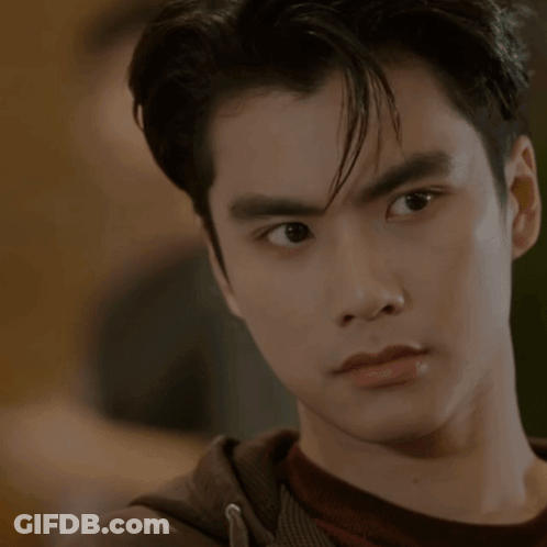 A Close Up Of A Young Man 'S Face With A Hand On His Chin GIF