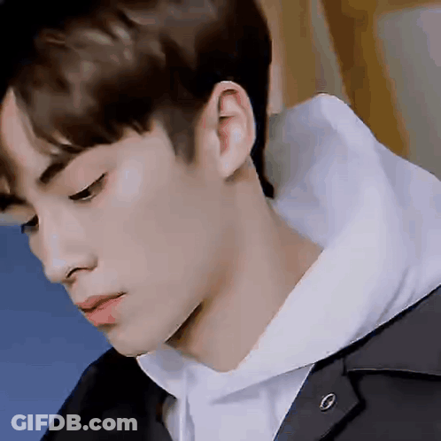 A Close Up Of A Young Man 'S Face With A Hoodie On . GIF
