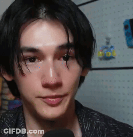 A Close Up Of A Young Man 'S Face With A Microphone . GIF