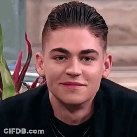 A Close Up Of A Young Man 'S Face With A Necklace Around His Neck . GIF