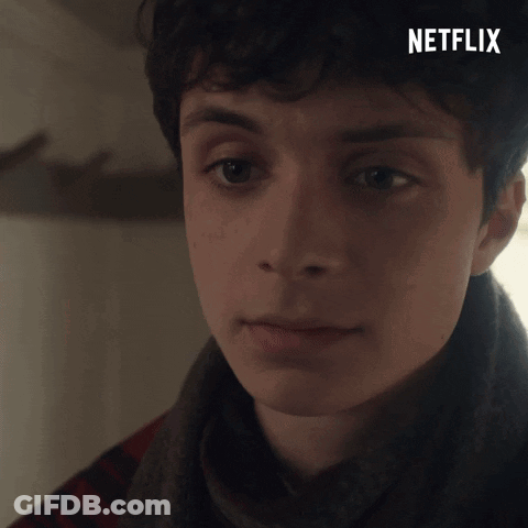 A Close Up Of A Young Man 'S Face With A Netflix Logo In The Background GIF