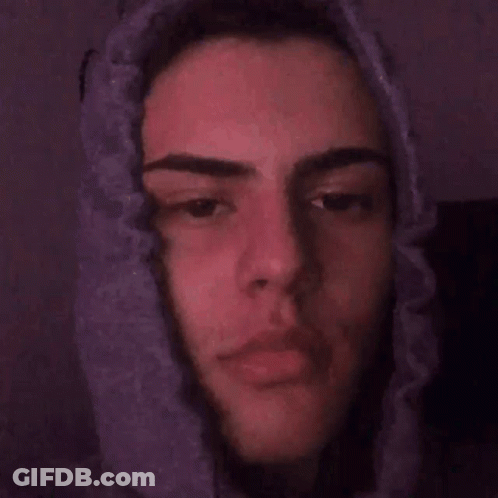 A Close Up Of A Young Man 'S Face With A Purple Background . GIF