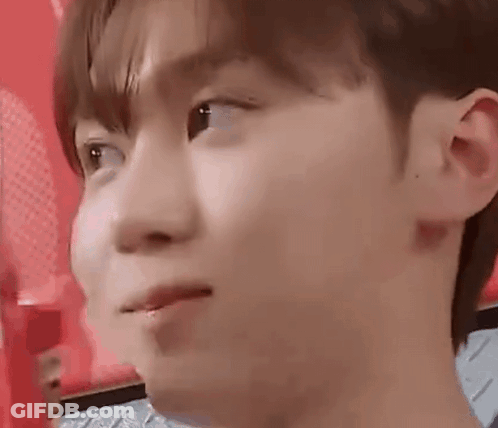 A Close Up Of A Young Man 'S Face With A Red Background Making A Face . GIF