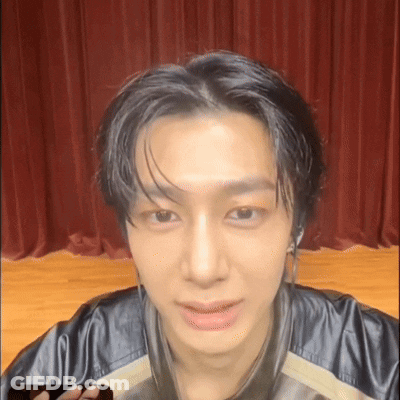 A Close Up Of A Young Man 'S Face With A Red Curtain In The Background GIF