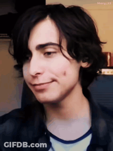 A Close Up Of A Young Man 'S Face With A Slight Smile GIF