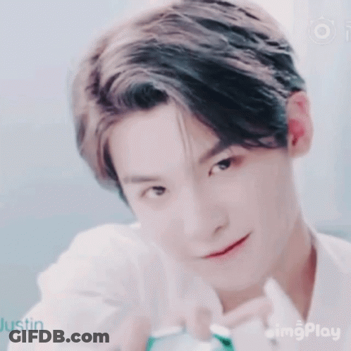 A Close Up Of A Young Man 'S Face With A Smile On His Face And A White Shirt On . GIF