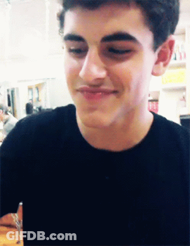 A Close Up Of A Young Man 'S Face With A Smile On His Face GIF