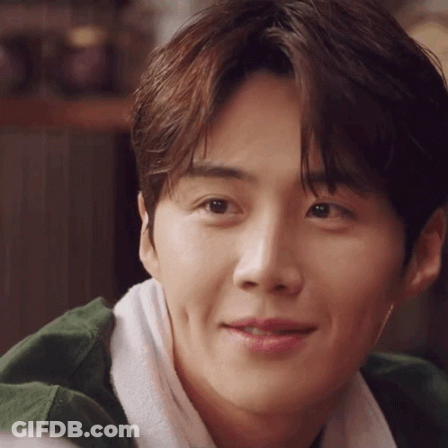 A Close Up Of A Young Man 'S Face With A Towel Around His Neck And A Green Jacket . GIF