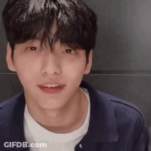 A Close Up Of A Young Man 'S Face With A White Shirt And A Blue Jacket . GIF