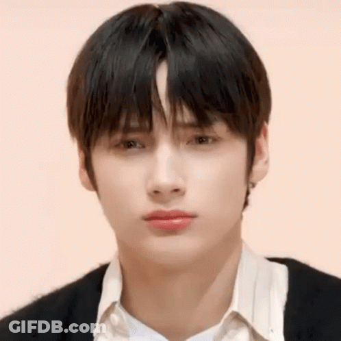 A Close Up Of A Young Man 'S Face With A White Shirt And Black Sweater . GIF