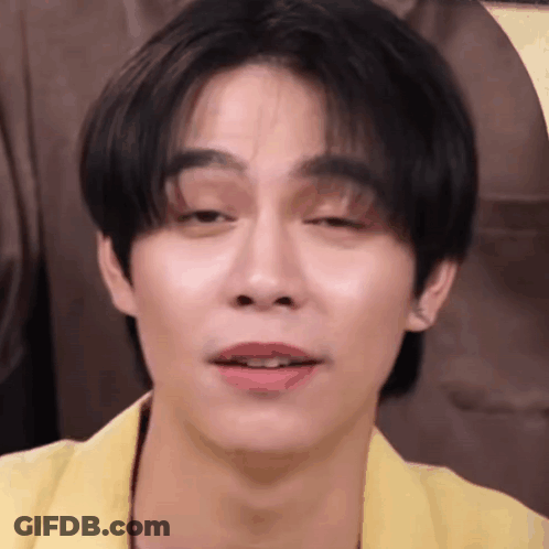 A Close Up Of A Young Man 'S Face With A Yellow Jacket On . GIF