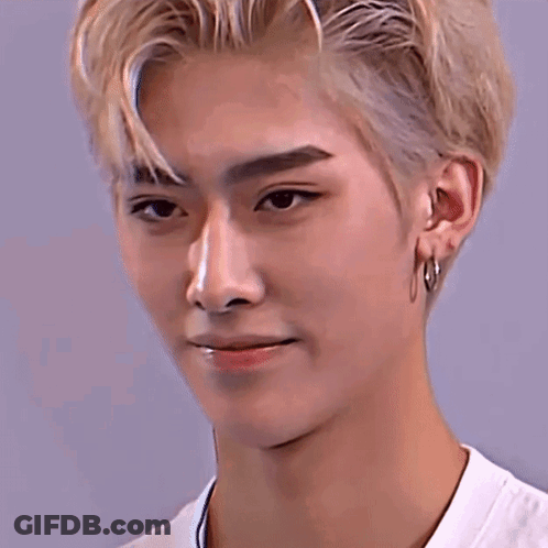 A Close Up Of A Young Man 'S Face With Blonde Hair And Hoop Earrings . GIF