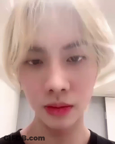 A Close Up Of A Young Man 'S Face With Blonde Hair And Red Lipstick . GIF