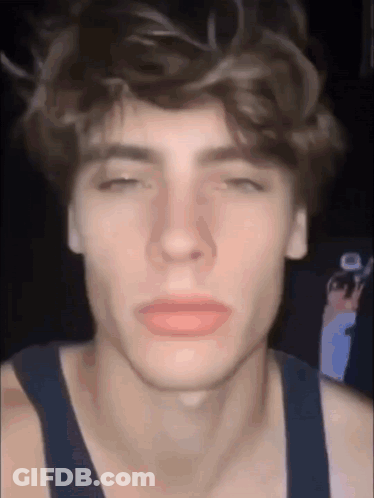 A Close Up Of A Young Man 'S Face With His Eyes Closed And His Mouth Open . GIF
