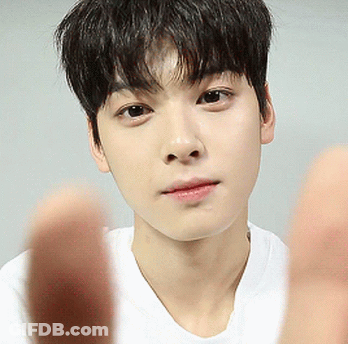 A Close Up Of A Young Man 'S Face With His Hands In Front Of Him GIF