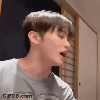 A Close Up Of A Young Man 'S Face With His Mouth Open . GIF