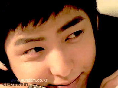 A Close Up Of A Young Man 'S Face With The Website Www.gundam.co.kr In The Background GIF