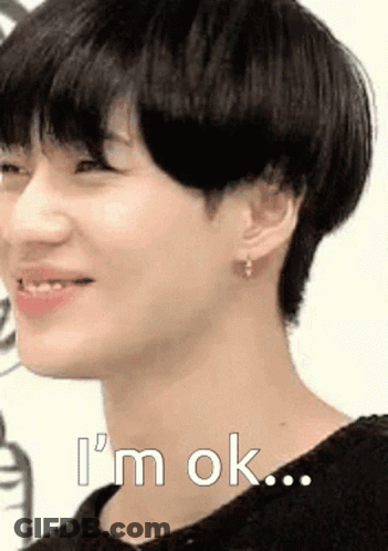 A Close Up Of A Young Man 'S Face With The Words `` I 'M Ok '' Written On It . GIF
