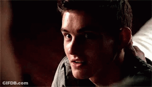 A Close Up Of A Young Man Smiling In A Dark Room . GIF