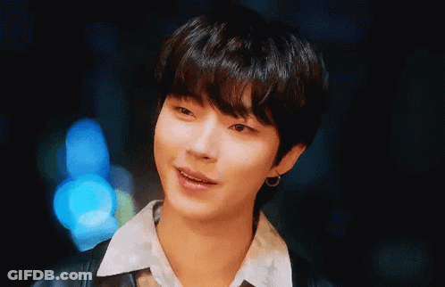 A Close Up Of A Young Man Wearing A Black Jacket And Earrings . GIF