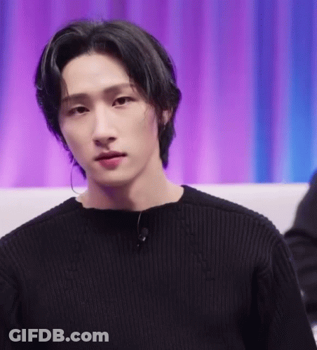 A Close Up Of A Young Man Wearing A Black Sweater And Earrings . GIF