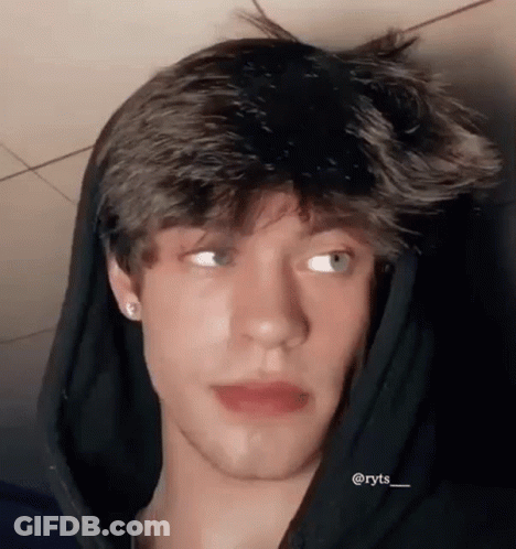 A Close Up Of A Young Man Wearing A Hoodie And Earrings . GIF