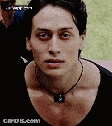 A Close Up Of A Young Man Wearing A Necklace . GIF