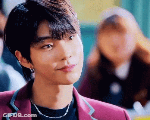 A Close Up Of A Young Man Wearing A Purple Jacket And A Necklace . GIF