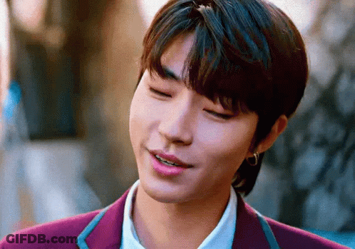 A Close Up Of A Young Man Wearing A Purple Suit And Earrings . GIF