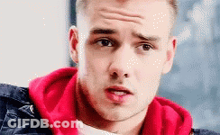 A Close Up Of A Young Man Wearing A Red Hoodie And A Black Jacket . GIF